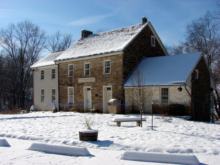 a small snow - covered house has two large windows