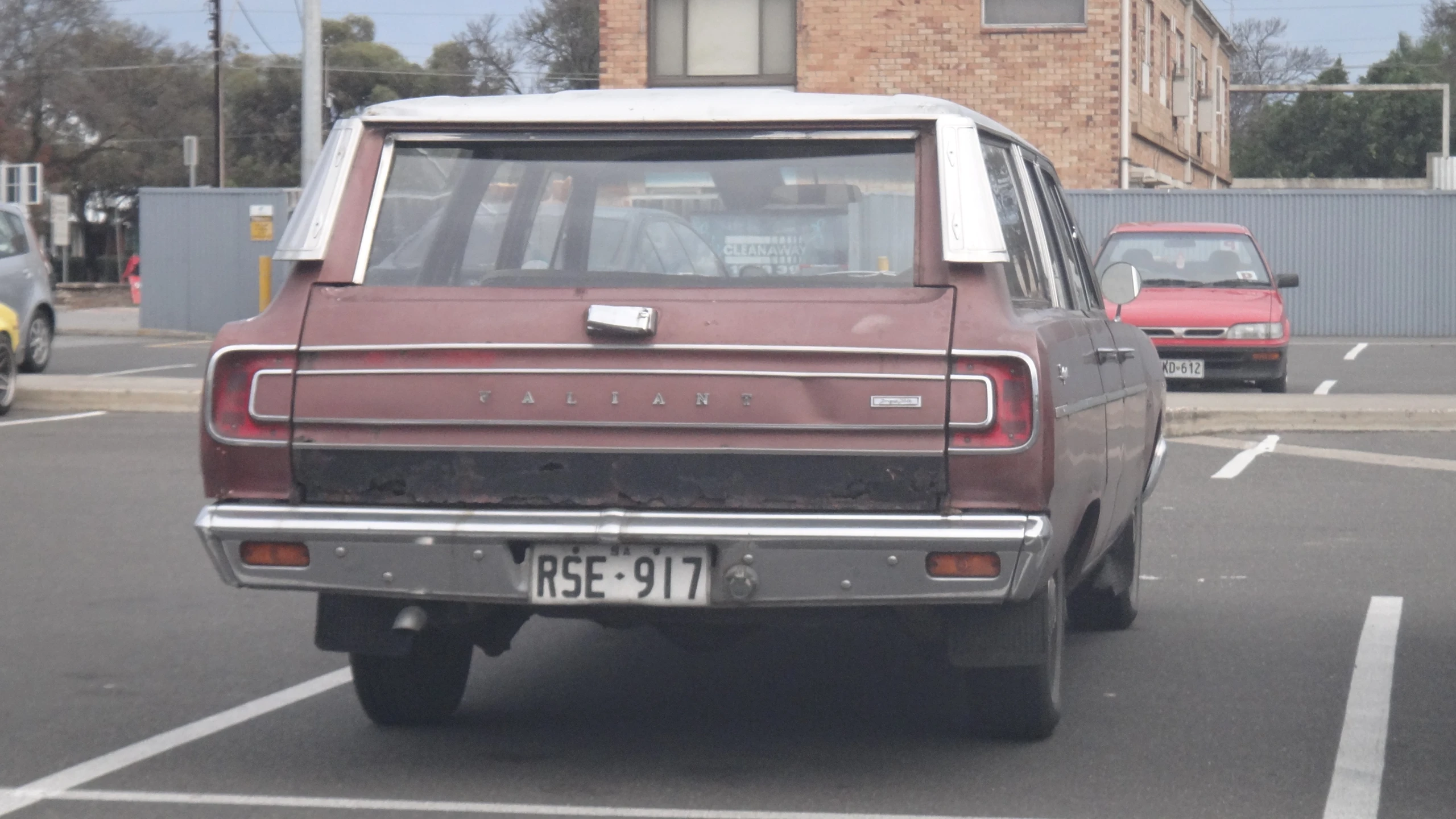 an older pickup truck with a smaller car behind it