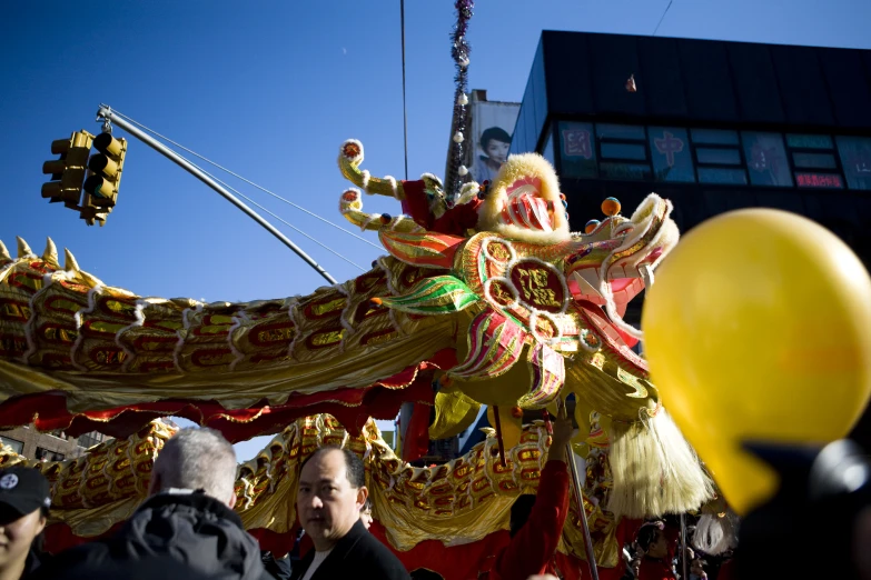 a yellow dragon is on display with people