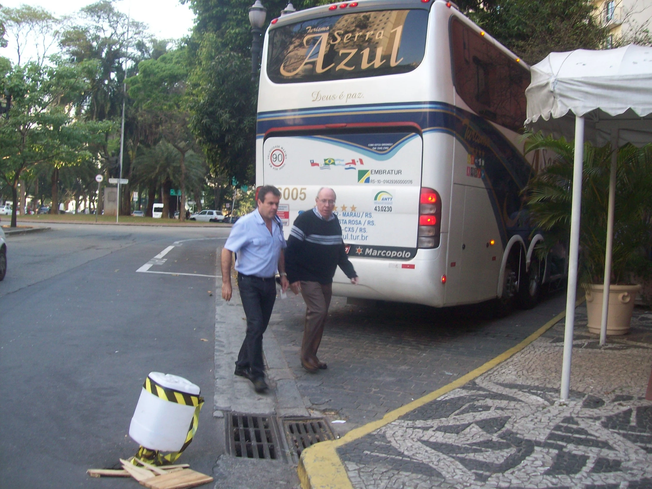 there is a male and female talking beside of a bus