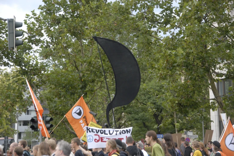 a group of people holding orange and black flags