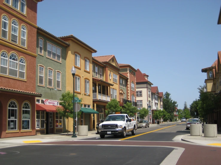 two trucks are driving on the street of the town