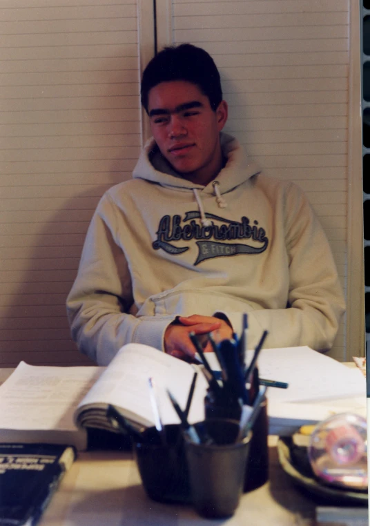 the young man is sitting at a table reading an open book