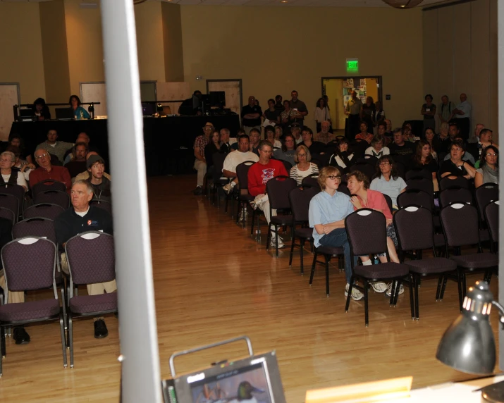 a large room full of people and a few with chairs