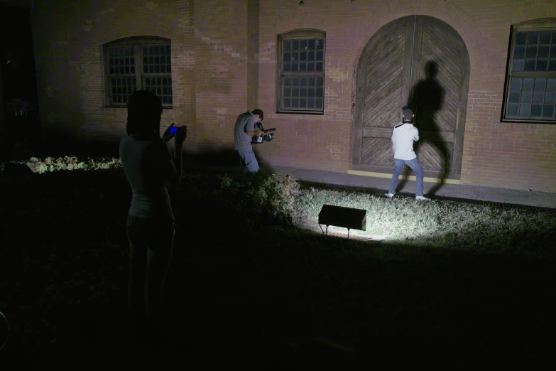 three men are taking pictures outside of a building