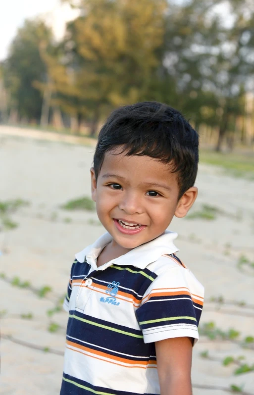 a  in striped shirt smiling for camera