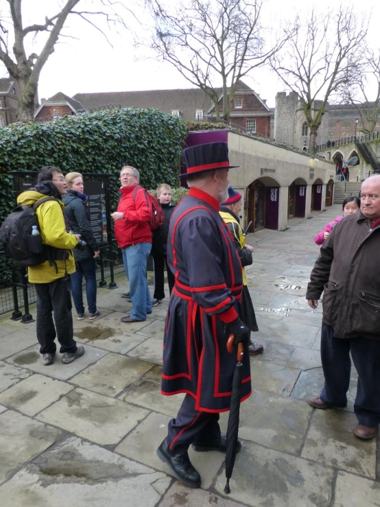 people gathered around an outside courtyard dressed in fancy clothes