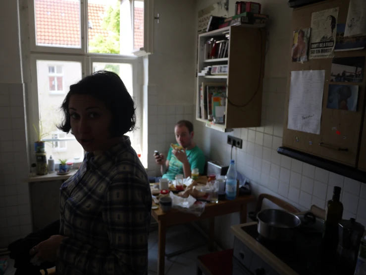 a man and woman are standing in a kitchen