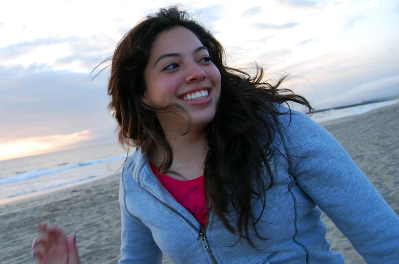 a woman holding a cell phone on a beach