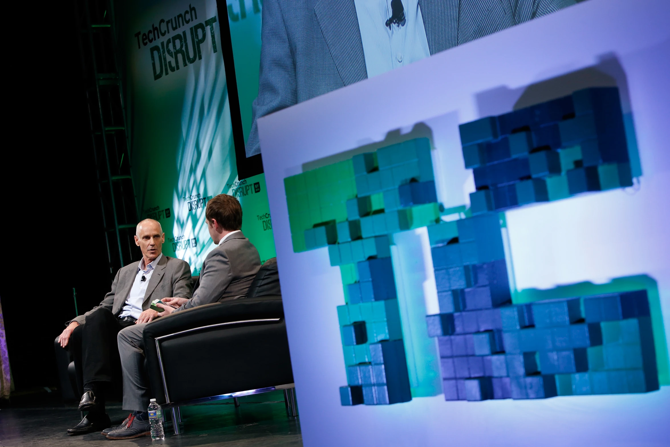 a man in a business suit talks on stage