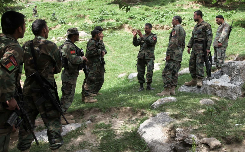 the soldiers are talking and holding a conversation together