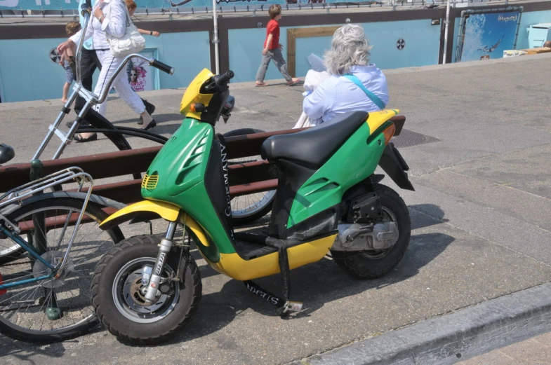 two women are riding a small motorbike