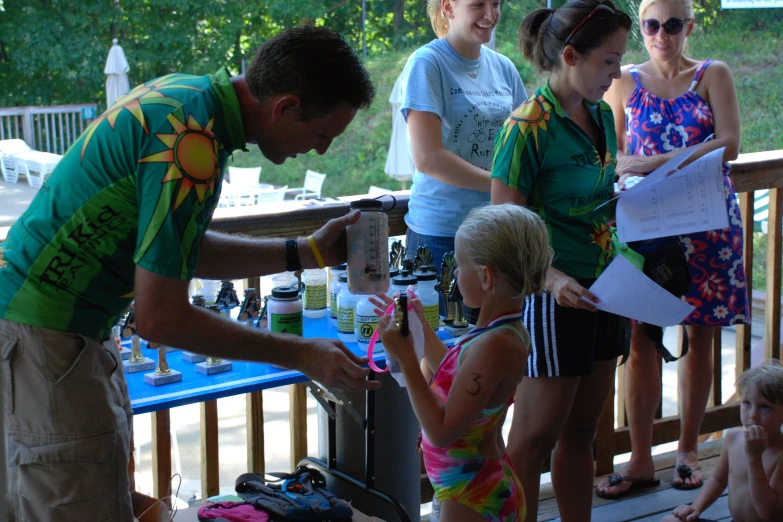 a man signing autographs for children to sit on a bench