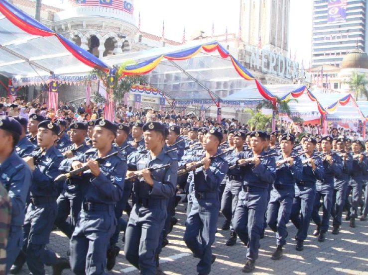 several military personnel marching in a large ceremony