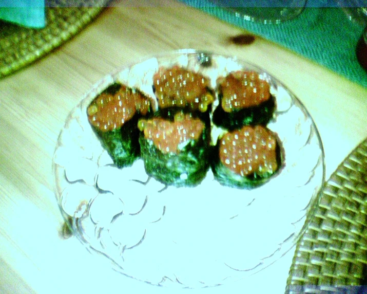 sushi on a white plate on top of a wooden table