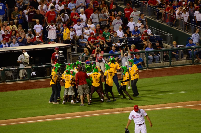 the group of baseball players is hugging on the field