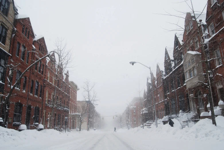 people on a road through some brick buildings covered in snow