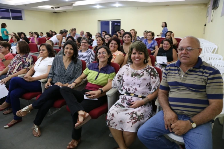 a group of people sit in chairs and watch