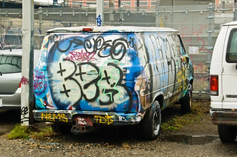 a van that is covered with graffiti and spray painted words