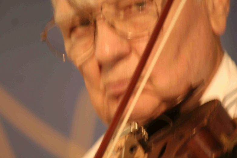 a blurry po of a man holding his violin