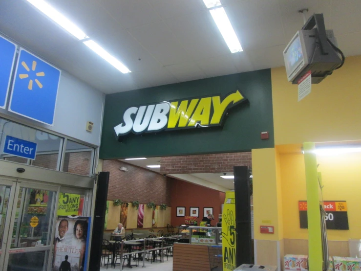 subway at an end of a mall with signs in front