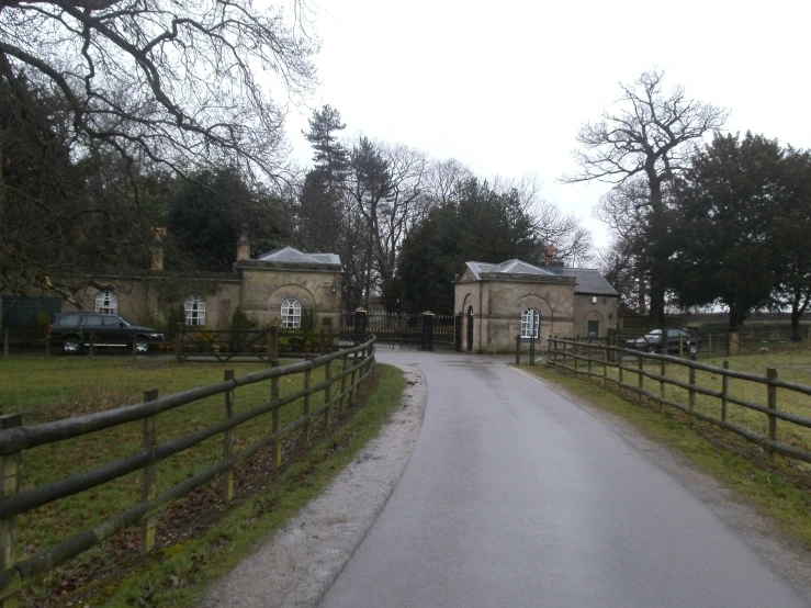 an old building is sitting near a wooden fence