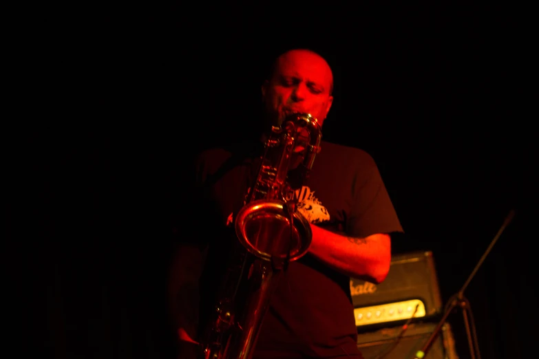a man playing on his trumpet with sound equipment behind him