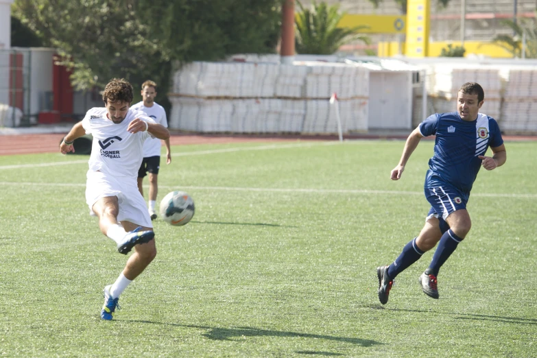 men playing soccer in a field on a sunny day