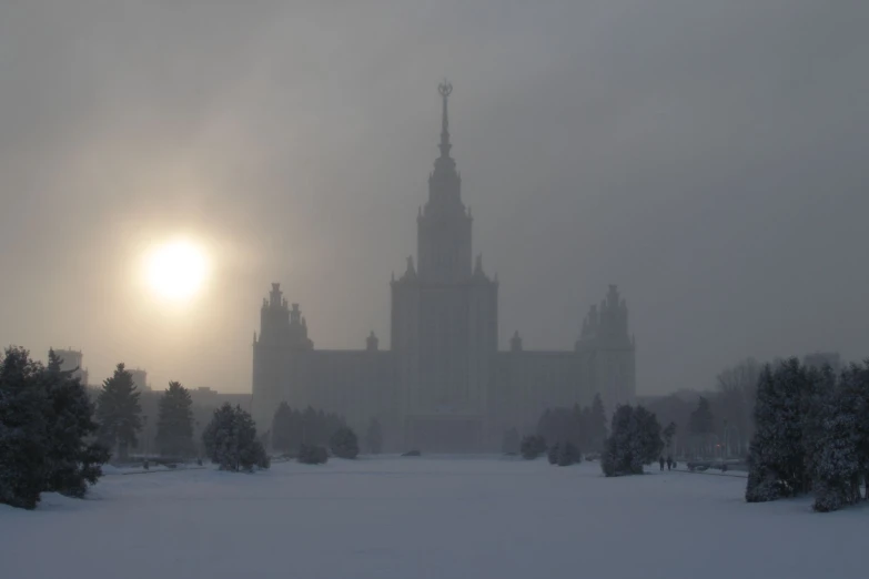 an image of the sun in the fog over a building