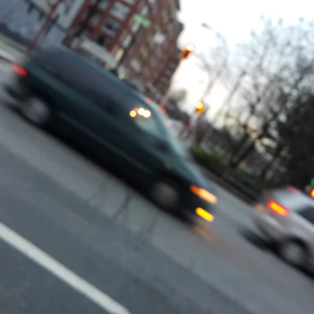 blurry view of a city street with cars driving by