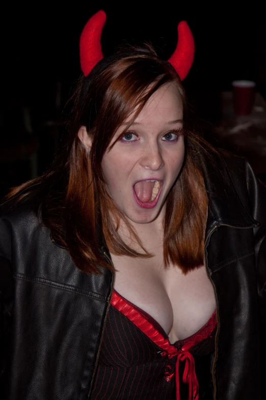 a woman in red devil ears making a face and s