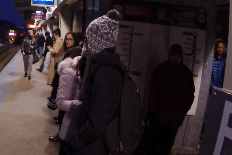 a group of people waiting for a subway train