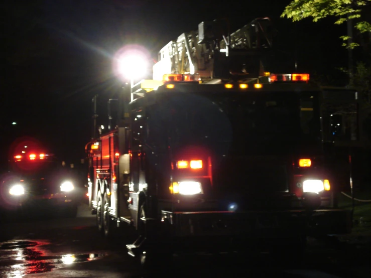 a fire truck driving down a street at night