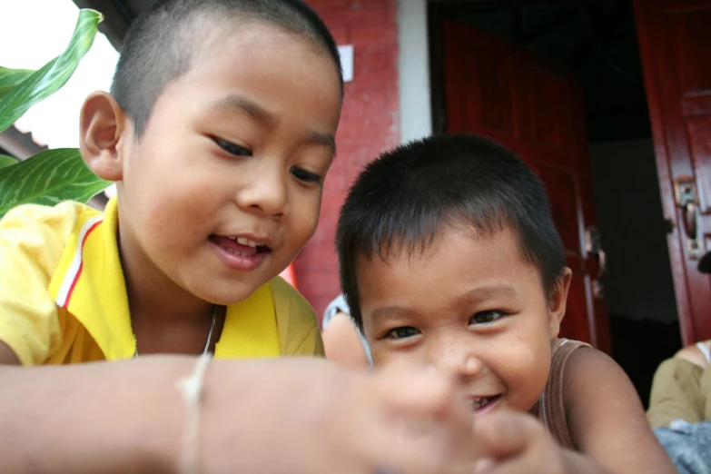 two s smiling and touching the fingers of each other