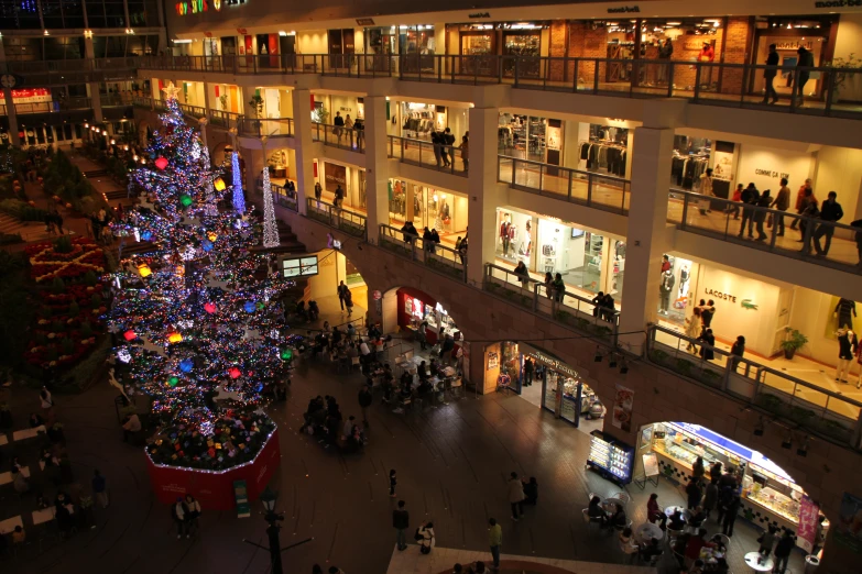 there is an illuminated christmas tree inside a shopping center