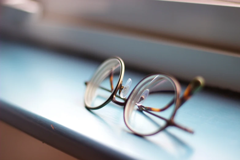 the glasses are resting on the ledge of the window sill