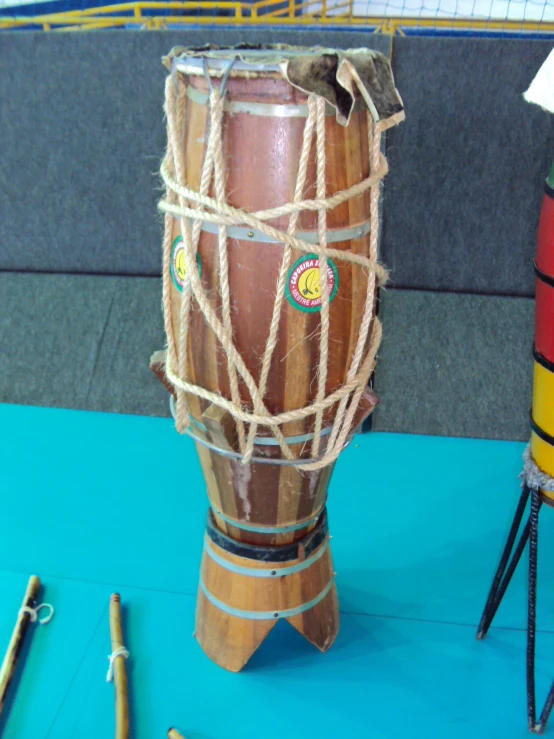 a wooden drum is on display with string wrapped around the drum