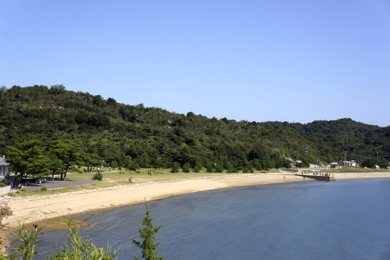 the beach is empty and blue on the hill behind it