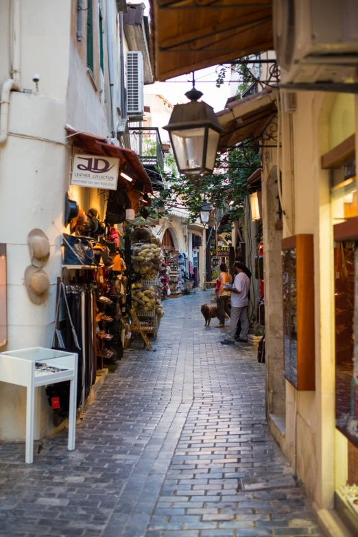 an alley way with people walking and sitting