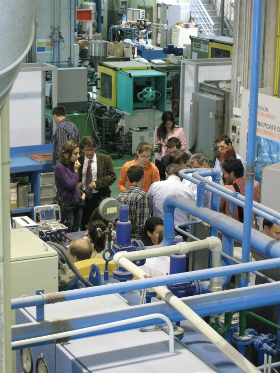 factory employees are at tables with machinery