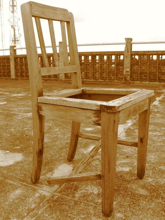 a weathered wooden chair sitting in the sand