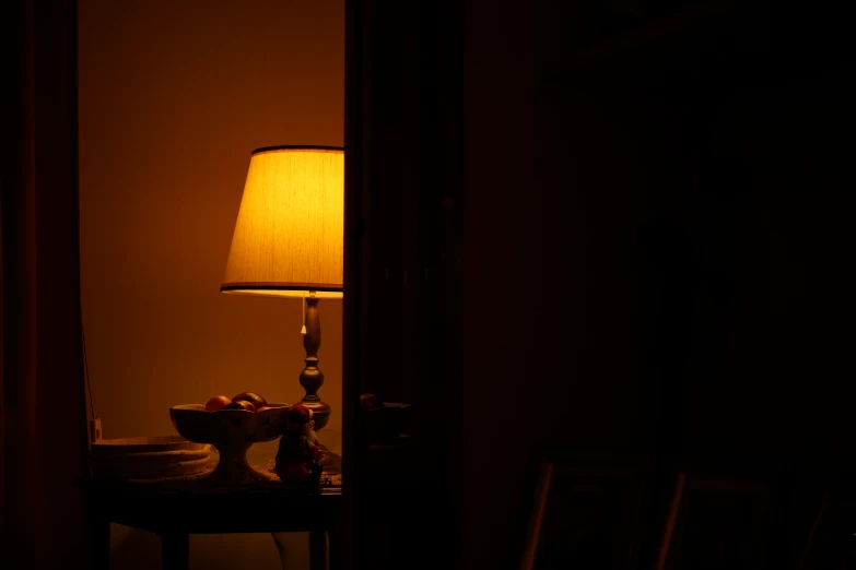 a dark room with a lamp and food on the table