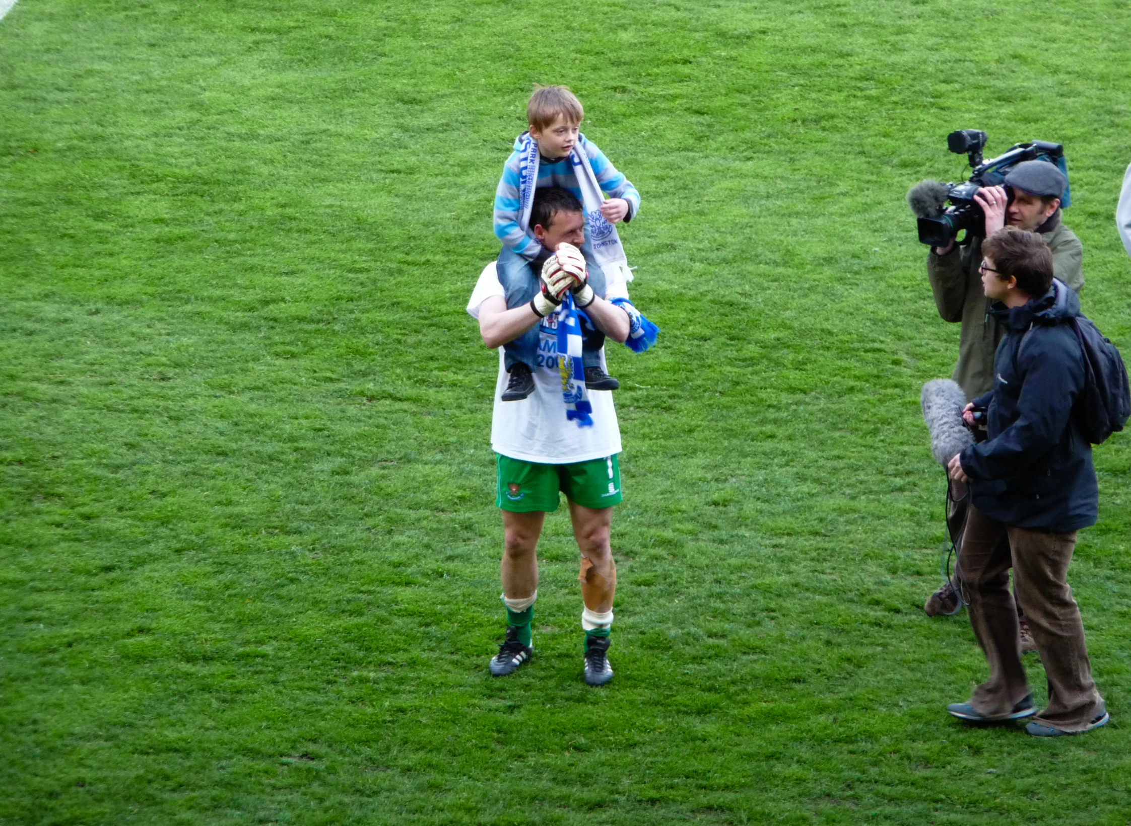 a person walking on a soccer field in a white shirt