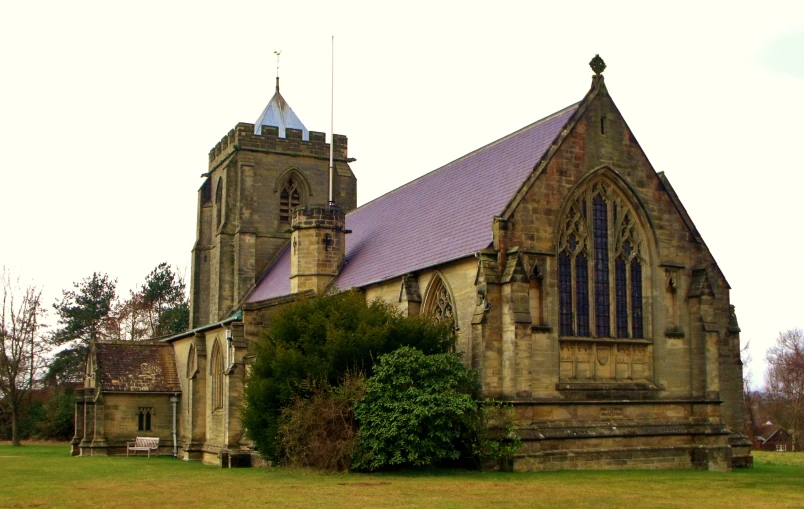 an old church is surrounded by trees and bushes