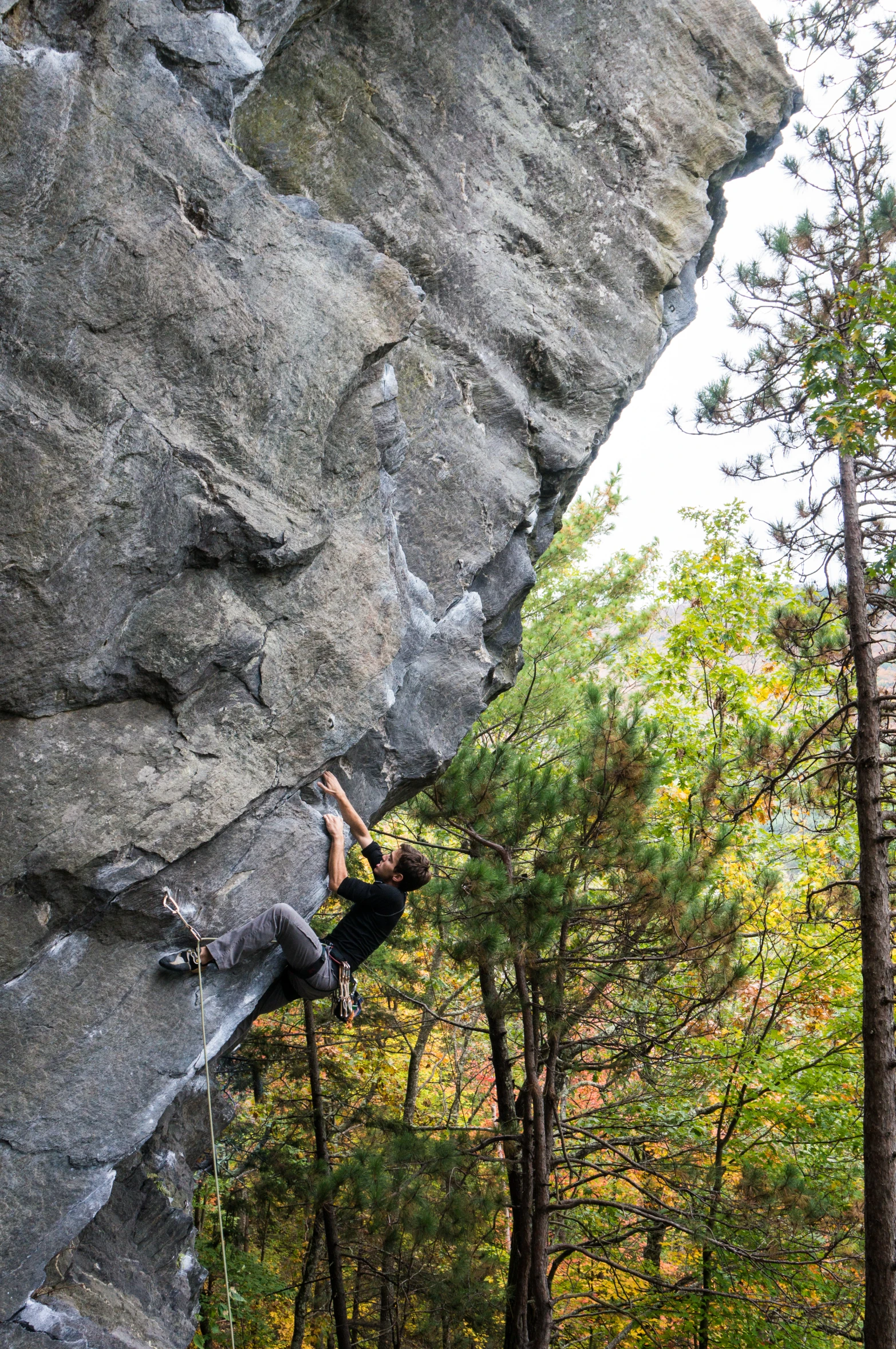 a person in a wetsuit climbing up a rock face