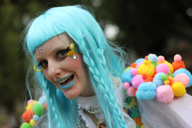 a man with blue hair and bright makeup