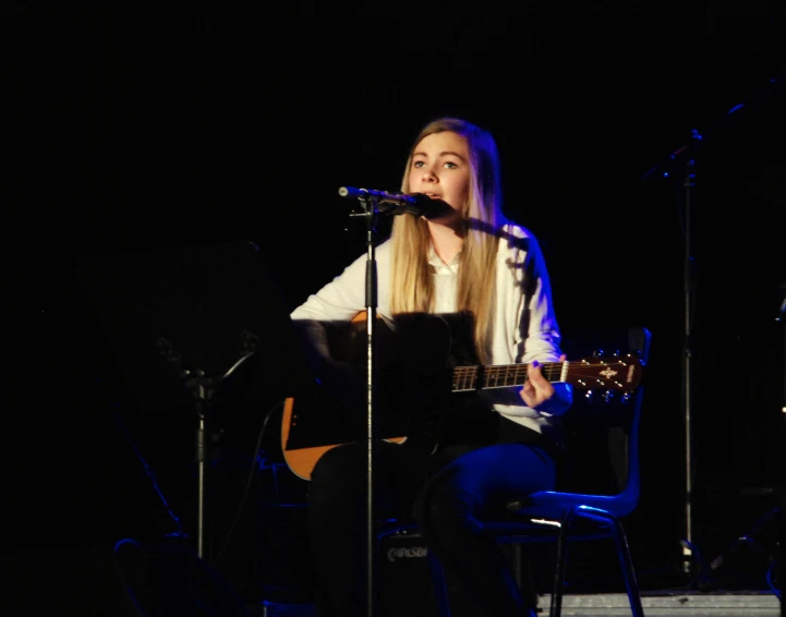 a woman sitting on top of a chair with an electric guitar