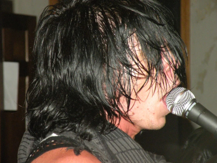 the back of a young man singing into a microphone