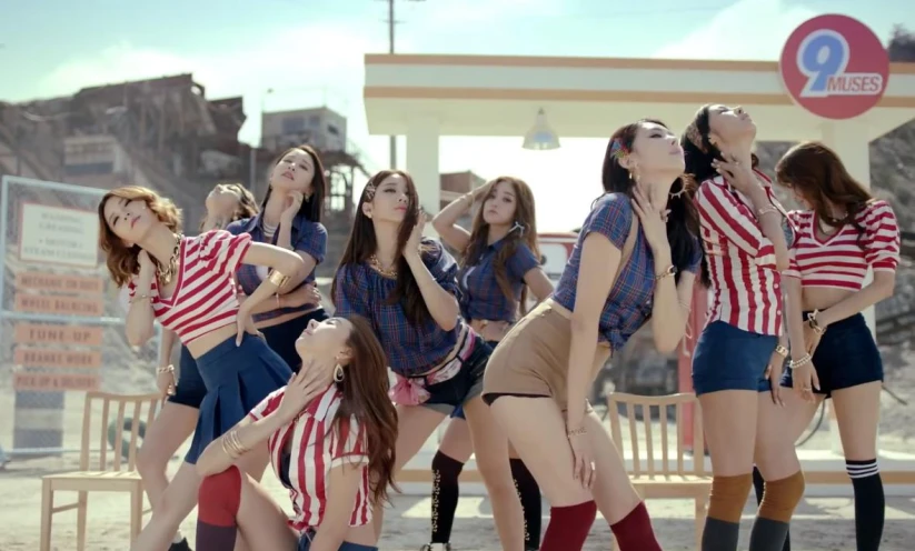 girls standing in uniform taking pictures at a gas station