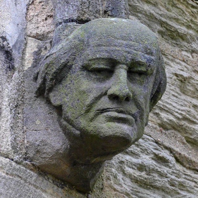 a close up of a stone statue of a man with his head up and looking at soing